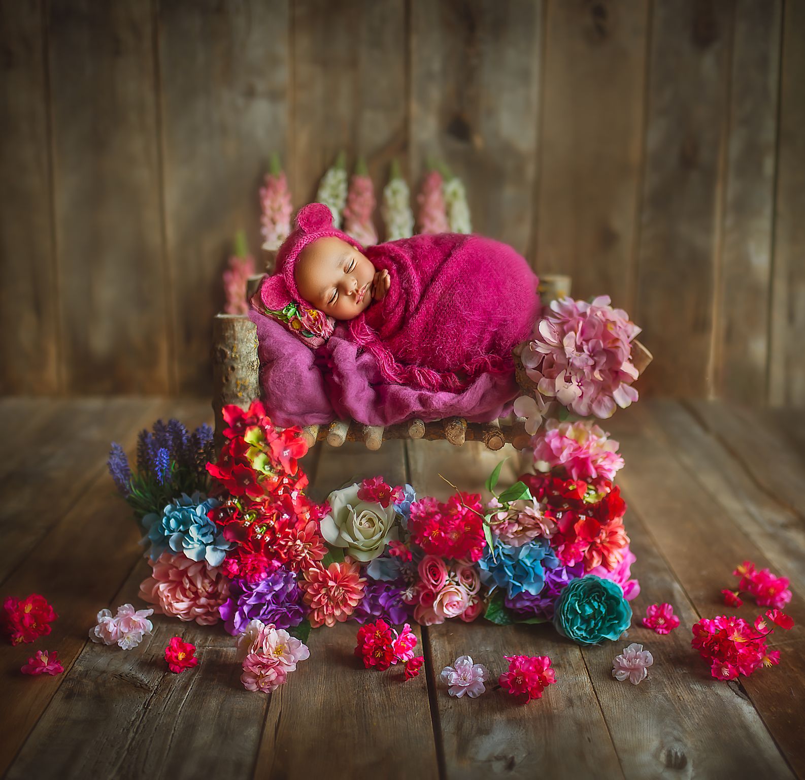 Conseils pour une séance photo maternité mémorable a baby sleeping on a small bed with flowers around it